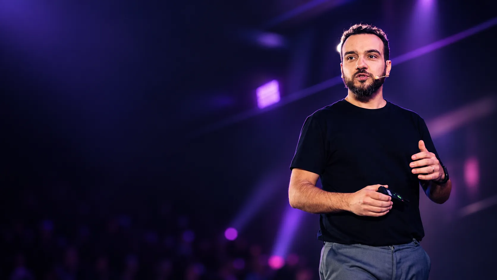 Netto Simões no palco, usando microfone e apresentando seu método